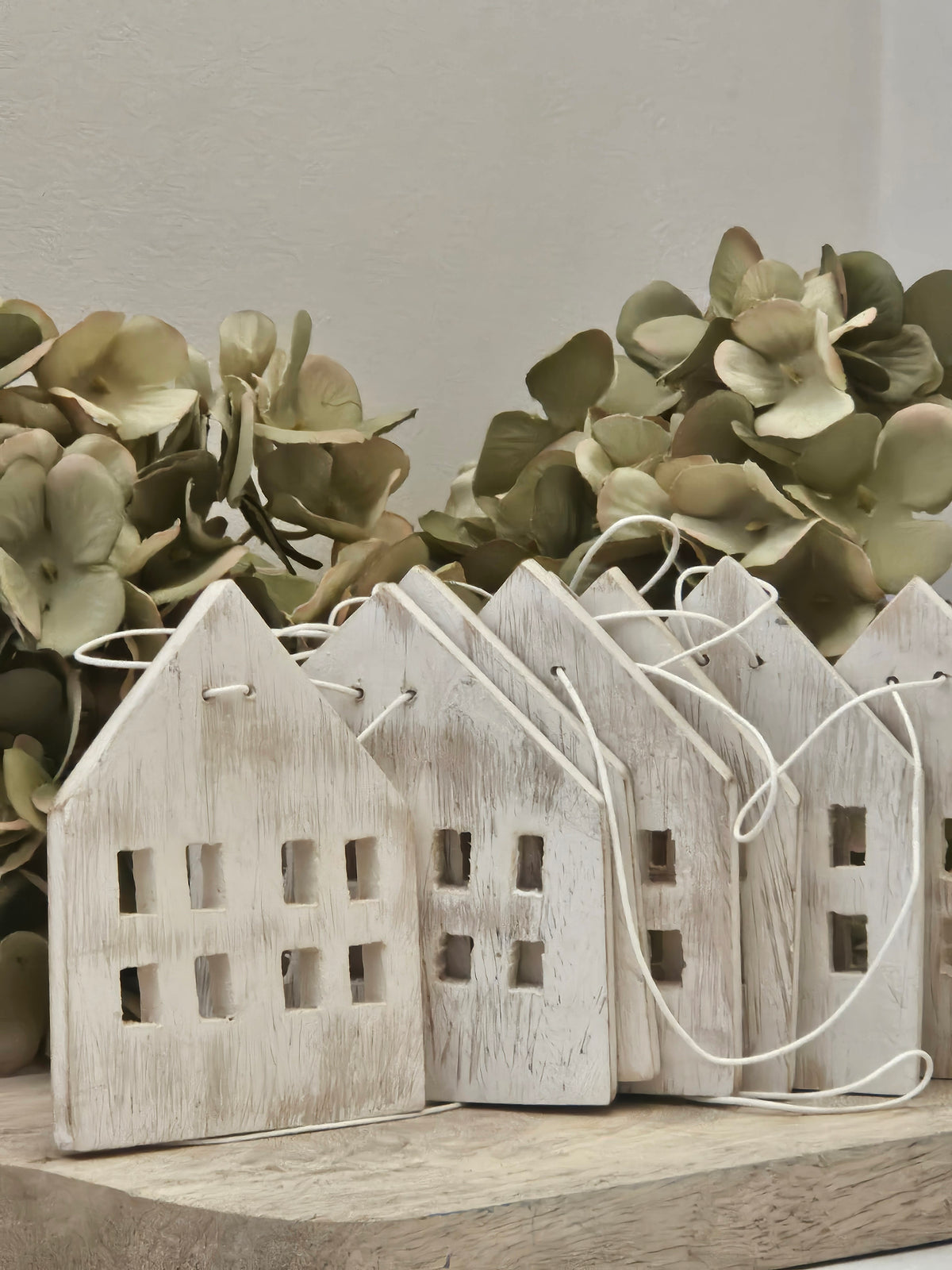 Whitewashed wooden garland of houses for festive decoration