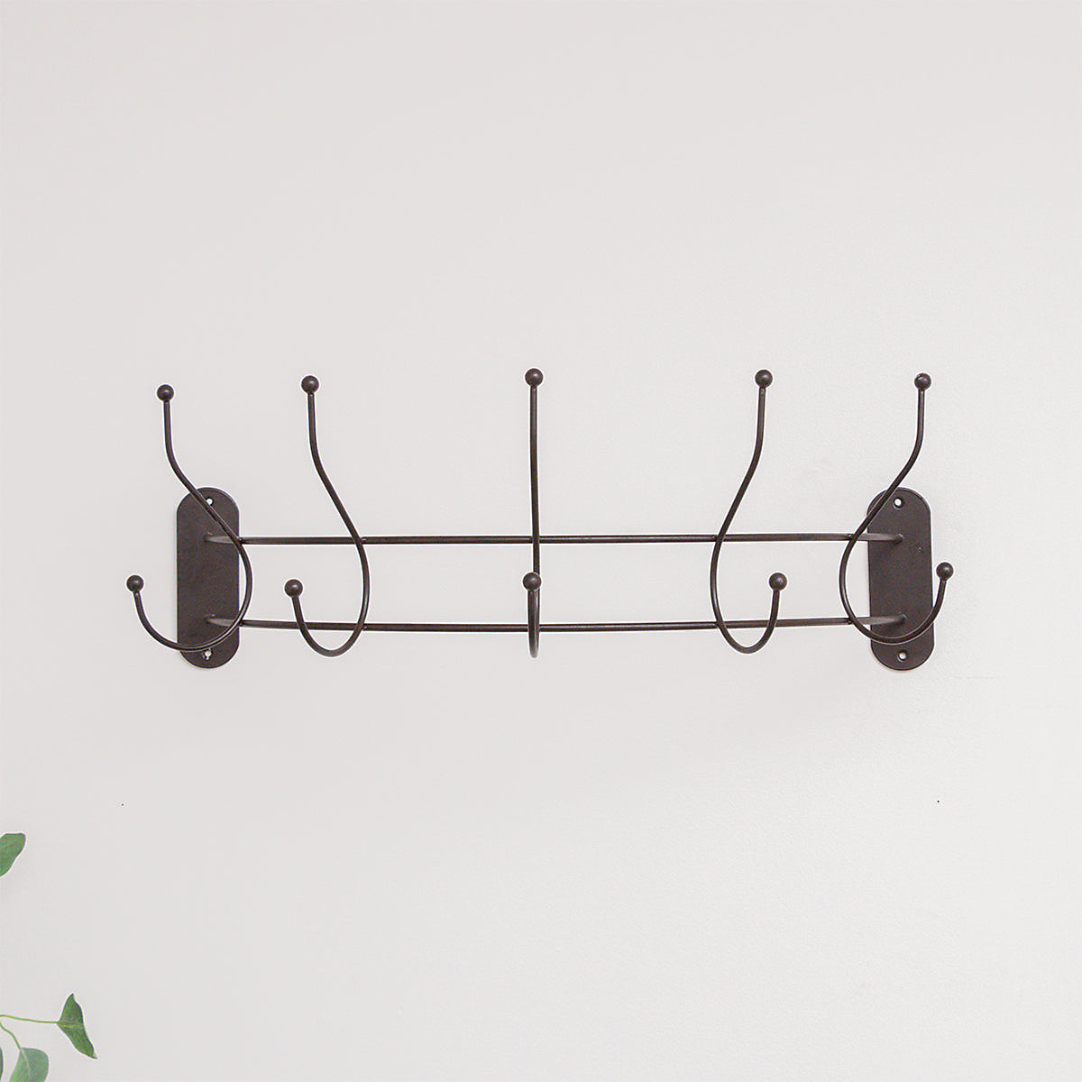 Antique dark bronze curved coat hanger rail for hallway